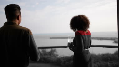 Couple enjoying view from balcony of sea
