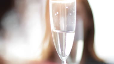 Female friends enjoying a glass of Champagne outdoors in sunshine