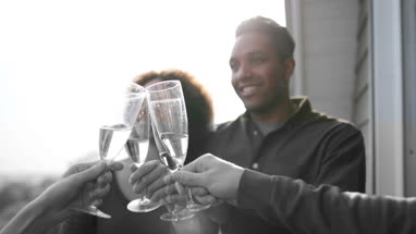 Female friends enjoying a glass of Champagne outdoors in sunshine
