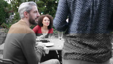 Female bringing plate of food to a table