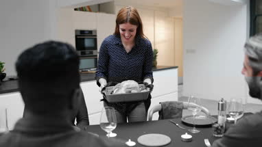 Adult female serving Christmas meal to friends