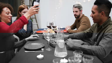 Female pouring friends wine at a meal
