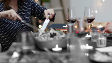 Close-up adult female serving Christmas meal to friends