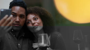 Couple looking at smartphone together at a meal