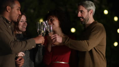 Friends drinking champagne outdoors at night