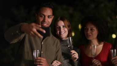 Friends celebrating outdoors taking a selfie