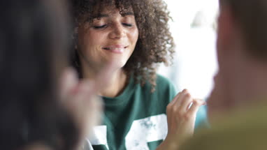 Young adult female showing friends photo on smartphone