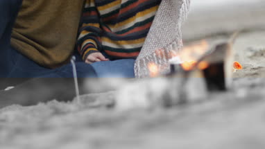 Young couple sheltering from rain under a blanket