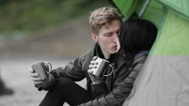 Young couple camping on the beach in fall