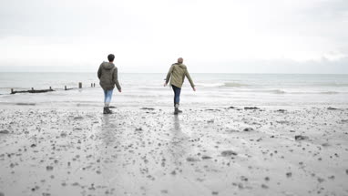 Young male friends skimming stones together