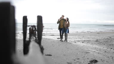 Young couple walking on a beach in winter
