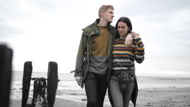 Young couple walking on a beach in winter