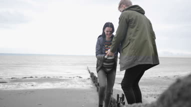 Boyfriend helping girlfriend climb a rock