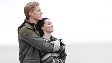 Couple hugging on a beach in winter