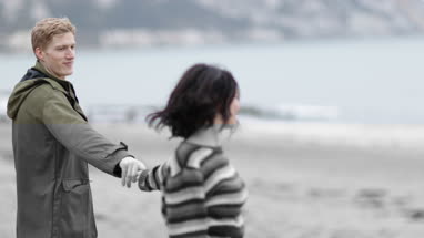 Young couple dancing on a beach in winter
