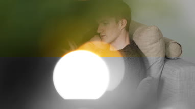 Couple at home cuddling on sofa at Christmas