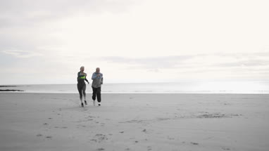 Senior woman in training running up staircase 