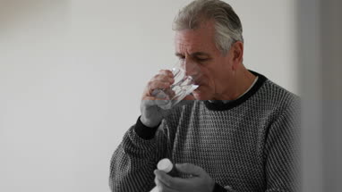 Senior man taking medicine