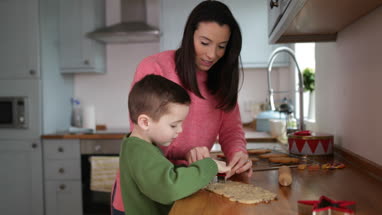 Mother and Son baking cookies in kitchen