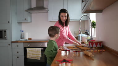 Mother and Son baking cookies in kitchen