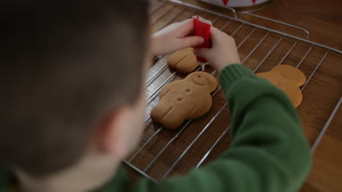 Boy decorating gingerbread men