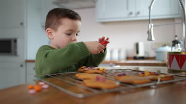 Boy decorating gingerbread men