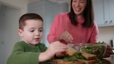 Boy making a sandwich with Mother helping