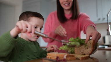 Boy making a sandwich with Mother helping