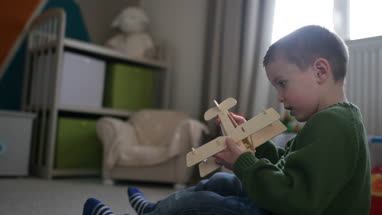 Boy playing with toy model plane