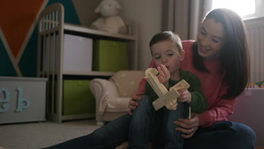 Mother and Son playing with toy model plane
