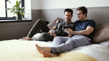 Young male couple looking at smarphone together