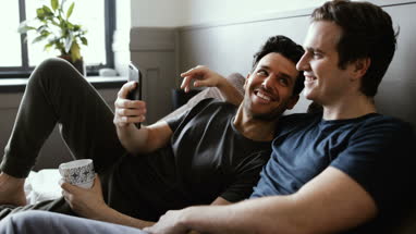Young male couple looking at smarphone together