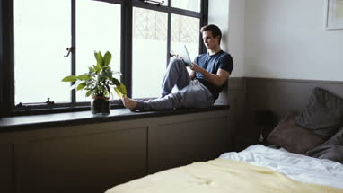 Young male with digital tablet in the morning