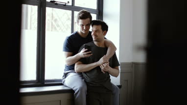 Young male couple making plans with smartphone