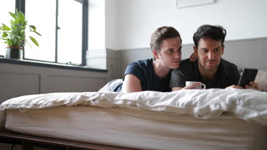 Young male couple looking at smarphone together