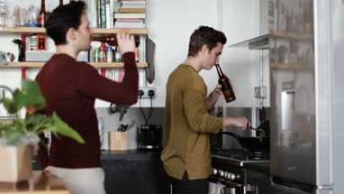 Young male couple cooking in kitchen
