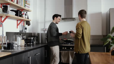 Young male couple cooking in kitchen