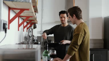 Young male couple cooking in kitchen
