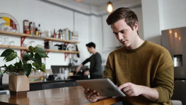 Young male using digital tablet at home