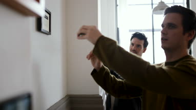 Young male couple measuring wall