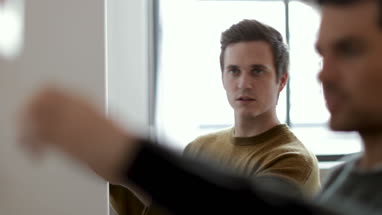 Young male couple measuring wall