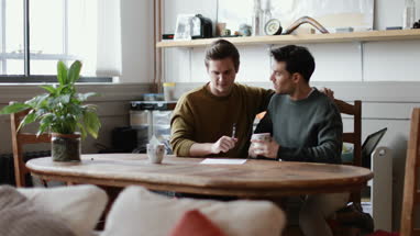 Young male couple signing legal document