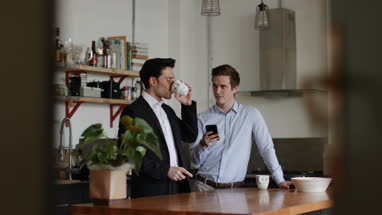 Young male couple kissing goodbye in the morning