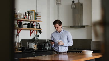 Businessman checking smartphone at home