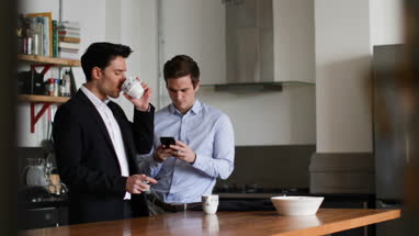 Young male couple kissing goodbye in the morning