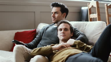 Young male couple relaxing on sofa