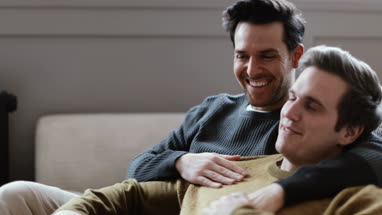 Young male couple relaxing on sofa
