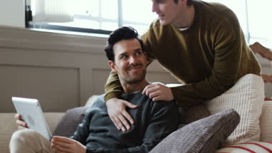 Young male couple looking at digital tablet