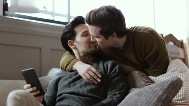 Young male couple looking at smartphone