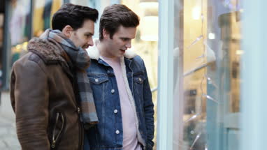 Young male couple window shopping
